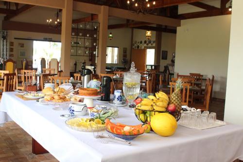 Pousada Sítio Pedras de Minas في مونتي سيو: طاولة بيضاء عليها صحون فاكهة