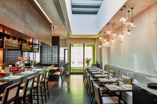 a dining room with long tables and chairs at ibis Melbourne Central in Melbourne