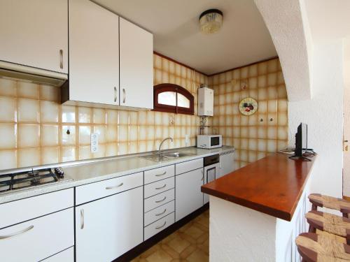 una cucina con armadi bianchi e ripiano in legno di Holiday Home Peces 3 by Interhome a Peñíscola