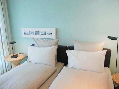 two beds with white pillows in a room at Apartment LaVille A-4-3 by Interhome in Locarno
