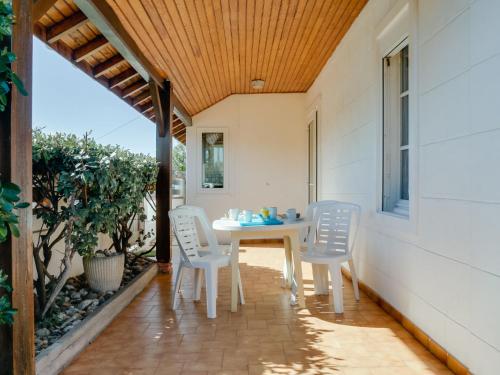 a porch with a white table and chairs on it at Holiday Home Remember by Interhome in Mimizan-Plage