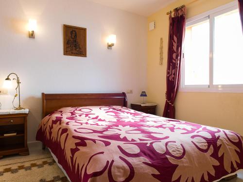 Schlafzimmer mit einem roten und weißen Bett und einem Fenster in der Unterkunft Apartment Vista Mar by Interhome in Cumbre del Sol