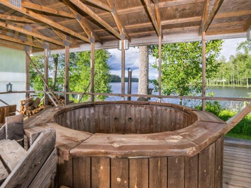 ein hölzerner Whirlpool auf einer Veranda mit Blick auf das Wasser in der Unterkunft Holiday Home Kannashovi by Interhome in Taipale