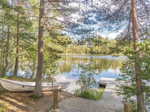 a boat sitting on the shore of a lake at Holiday Home Valkealammi by Interhome in Vehmainen