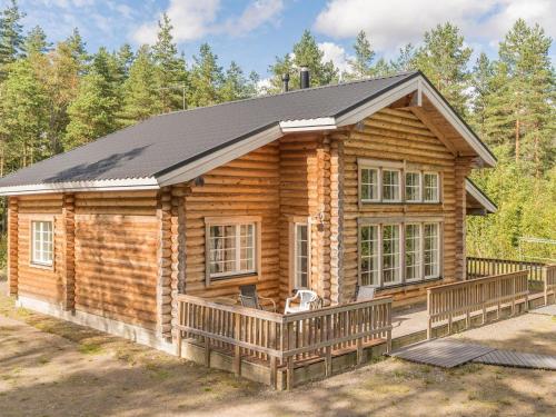 uma cabana de madeira com um alpendre e um deque em Holiday Home Valkealammi by Interhome em Vehmainen