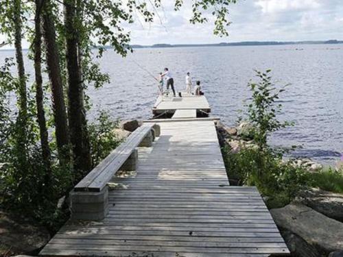 een groep mensen die vissen op een dok op een meer bij Holiday Home Karikko by Interhome in Lestijärvi