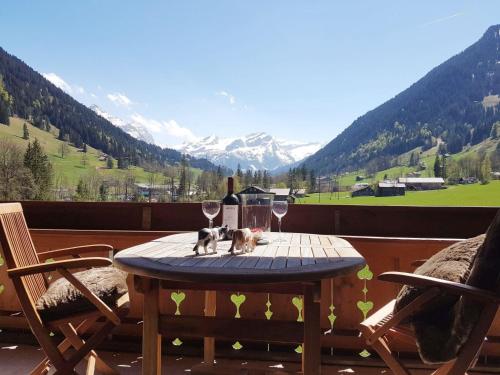 due gatti seduti su un tavolo con bicchieri da vino di Apartment Farfalla by Interhome a Gstaad