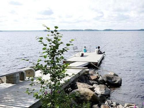 twee mensen op een steiger op een meer bij Holiday Home Karikko by Interhome in Lestijärvi