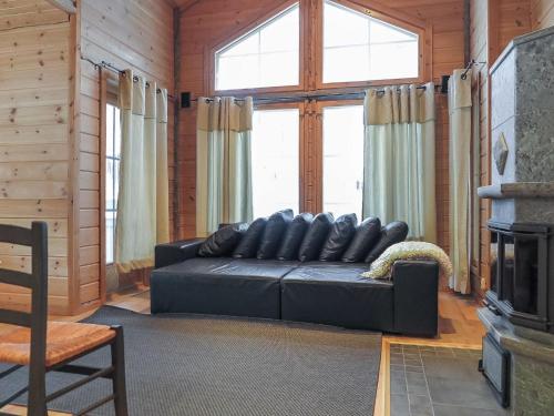 uma sala de estar com um sofá de couro preto e uma lareira em Holiday Home Poronpurema a by Interhome em Levi
