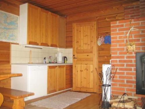 uma cozinha com armários de madeira e uma porta num quarto em Holiday Home Takaharju by Interhome em Karvonen