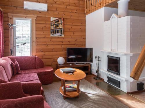 a living room with a couch and a fireplace at Holiday Home Peiponpesä b by Interhome in Tahkovuori