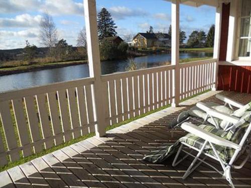 - deux chaises sur une terrasse couverte avec vue sur la rivière dans l'établissement Holiday Home Vauvila by Interhome, à Kyynämäki