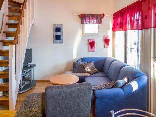 a living room with a blue couch and a table at Holiday Home Point vale 4 ap-3 by Interhome in Tahkovuori