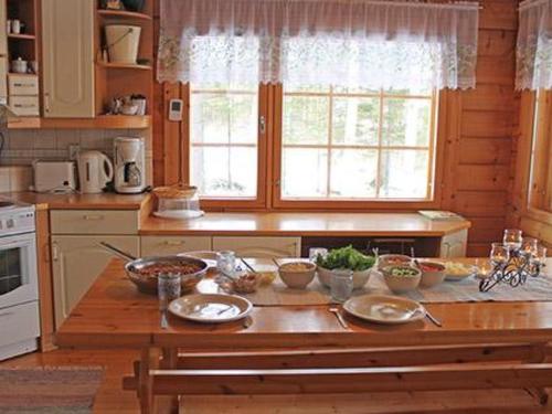 eine Küche mit einem Tisch mit Schüsseln voller Essen darauf in der Unterkunft Holiday Home Linnunlaulu by Interhome in Atro