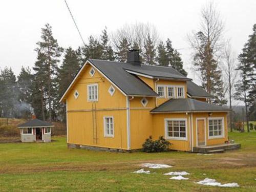 une maison jaune avec un toit noir dans une cour dans l'établissement Holiday Home Muonamies by Interhome, à Kyynämäki