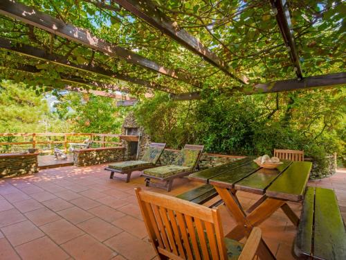 un patio con mesa y sillas bajo una pérgola en Holiday Home Villa Poggiobello by Interhome, en Massa