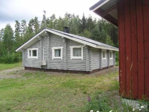 una pequeña casa en un campo al lado de un edificio rojo en Holiday Home Niittymökki by Interhome, en Somerniemi