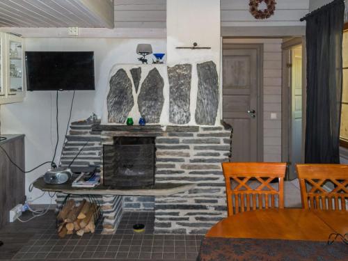 een woonkamer met een stenen open haard en een televisie bij Holiday Home Lomasyväri 806 by Interhome in Tahkovuori