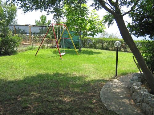 a park with a swing set in the grass at Apartment Jacopo-2 by Interhome in Santa Maria