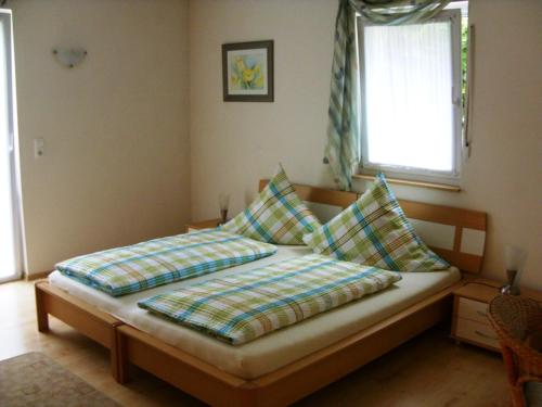 ein Bett mit zwei Kissen auf einem Zimmer in der Unterkunft Pension Fitnessoase in Eußenheim