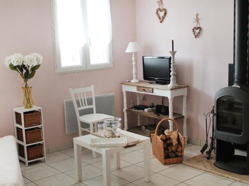 a living room with a tv and a stove at Chalet Le Clos des Sapins by Interhome in Monlet