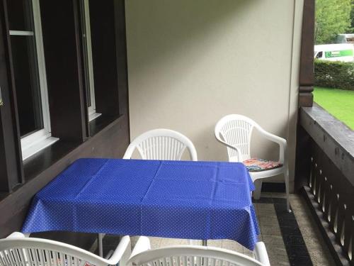 グスタードにあるApartment Oberland Nr- 19 by Interhomeの青いテーブルと椅子が置かれたポーチ