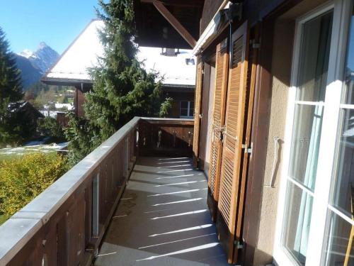 una pasarela fuera de una casa con ventana en Apartment Suzanne Nr- 18 by Interhome en Gstaad