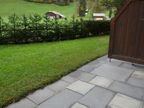 a walkway leading to a yard with a fence and grass at Apartment Oberland Nr- 7 by Interhome in Gstaad
