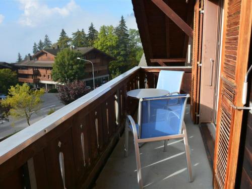 uma cadeira azul e uma mesa numa varanda em Apartment Arlette Nr- 30 by Interhome em Gstaad