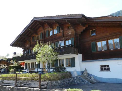 a large wooden house with a fence in front of it at Apartment Bolgen by Interhome in Zweisimmen