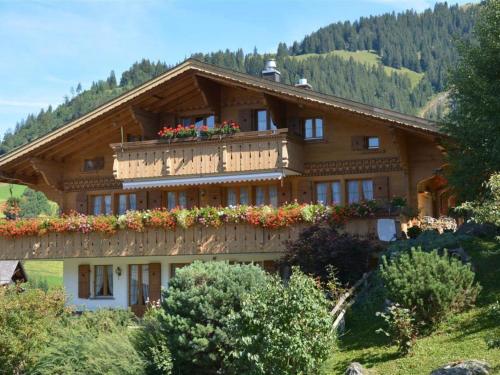 una gran casa de madera con flores en el balcón en Apartment Alegria - Parterre by Interhome, en Gstaad