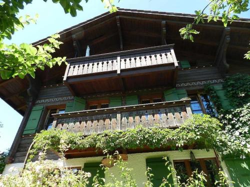 ein Gebäude mit einem Balkon mit Pflanzen in der Unterkunft Apartment Im Wiesengrund by Interhome in Gstaad
