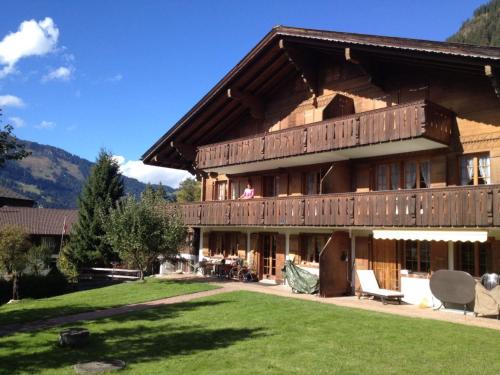 ein großes Holzhaus mit Rasen davor in der Unterkunft Apartment Favre OG Ost by Interhome in Matten