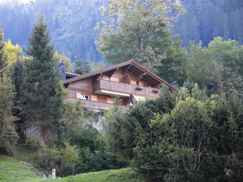 a house on the side of a hill with trees at Apartment Eichhorn by Interhome in Zweisimmen