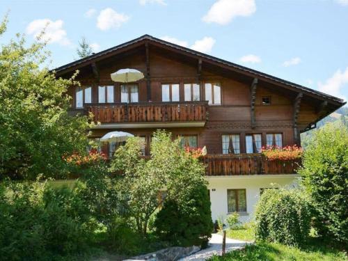 Cette grande maison en bois possède un balcon. dans l'établissement Apartment Abendrot by Interhome, à Gstaad