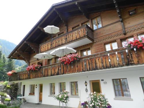 - un bâtiment avec un balcon doté de parasols dans l'établissement Apartment Abendrot by Interhome, à Gstaad