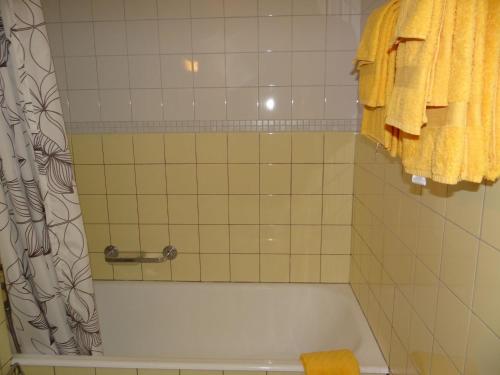 een badkamer met een bad en een gele handdoek bij Apartment Neuschwändi 63 by Interhome in Engelberg