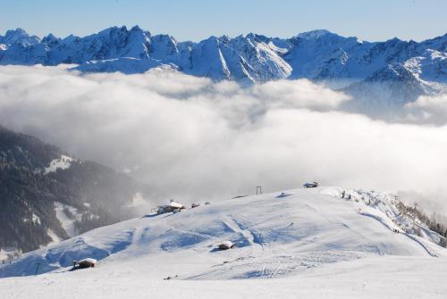 a snow covered mountain with clouds in the background at Bucherhof in Obertilliach
