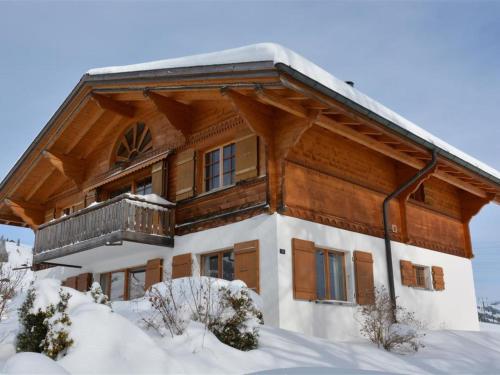 a log cabin with a balcony in the snow at Apartment Scapa by Interhome in Gstaad