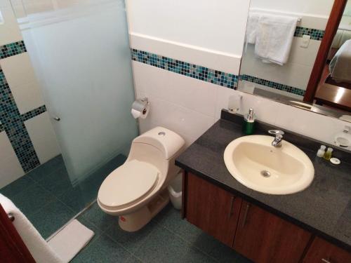 a bathroom with a toilet and a sink at Hotel Casa Sayu in Tumbaco