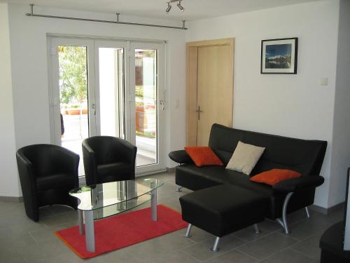 サースフェーにあるHoliday Home Haus Alpenstern- Wohnung Trift by Interhomeのリビングルーム(ソファ、椅子、ガラステーブル付)