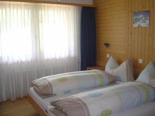 - une chambre avec 2 lits et une fenêtre dans l'établissement Haus Le Mirage, à Saas-Fee