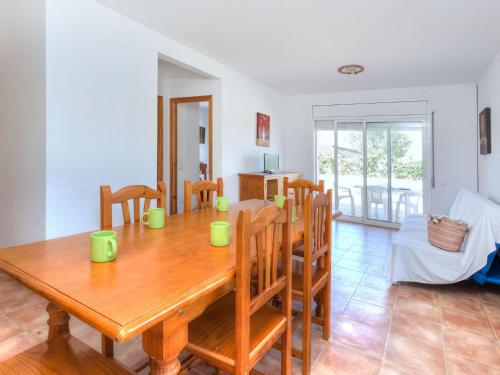 a dining room with a wooden table and chairs at Holiday Home Villa Santa Marta I by Interhome in Les tres Cales