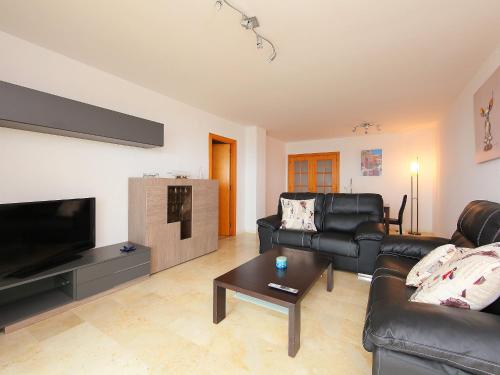 a living room with black leather furniture and a flat screen tv at Apartment Blanes Playa by Interhome in Blanes