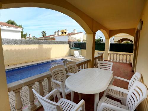 una mesa blanca y sillas en un balcón con piscina en Holiday Home Tatiana by Interhome, en Riumar