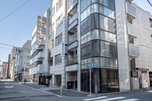 Kakigara Ryokan في طوكيو: مبنى زجاجي طويل على شارع المدينة