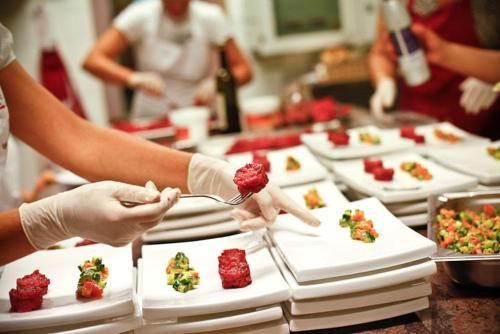 a group of people in a kitchen preparing food at Albergo Isetta in Grancona