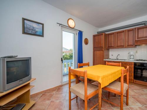 uma sala de jantar com uma mesa amarela e uma televisão em Apartment Hilde Blue-8 by Interhome em Medulin