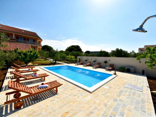 a swimming pool with lounge chairs and a swimming pool at Apartment Jasminka-1 by Interhome in Drage