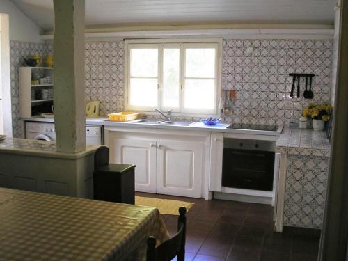 萊昂的住宿－萊昂曼森哈雷巴爾多度假屋，厨房配有白色橱柜、水槽和窗户。